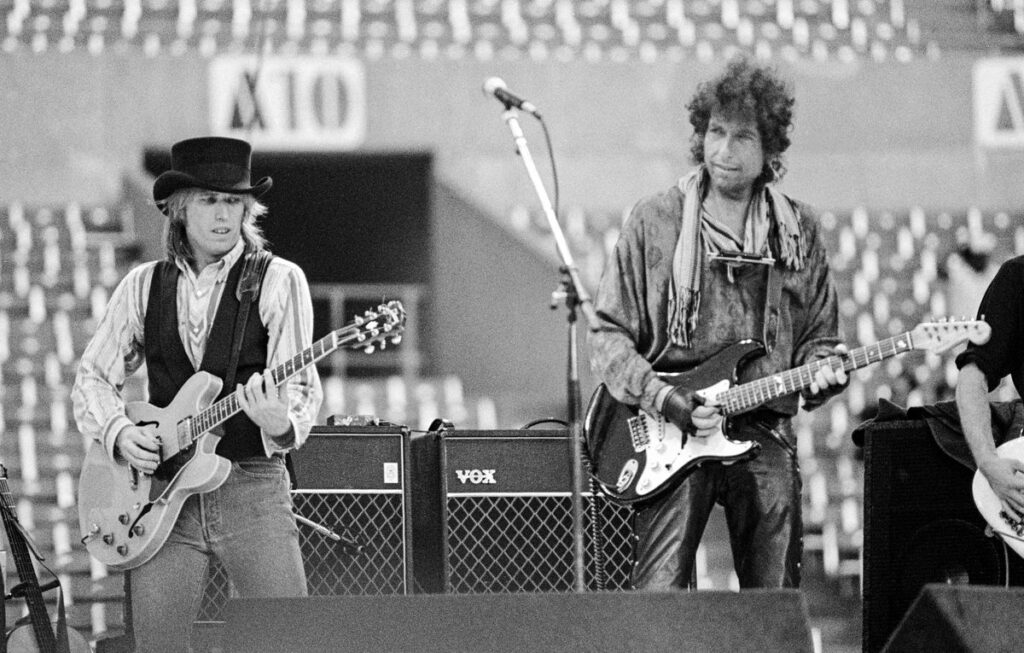 Tom Petty and Bob Dylan performing together on stage at Rich Stadium, Buffalo NY, July 4, 1986 - concert photography by Chuck Spang