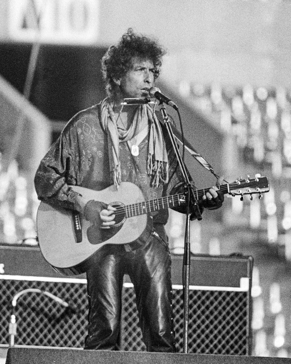 Bob Dylan playing acoustic guitar and harmonica at Rich Stadium, Buffalo NY, 1986 True Confessions Tour - concert photography by Chuck Spang