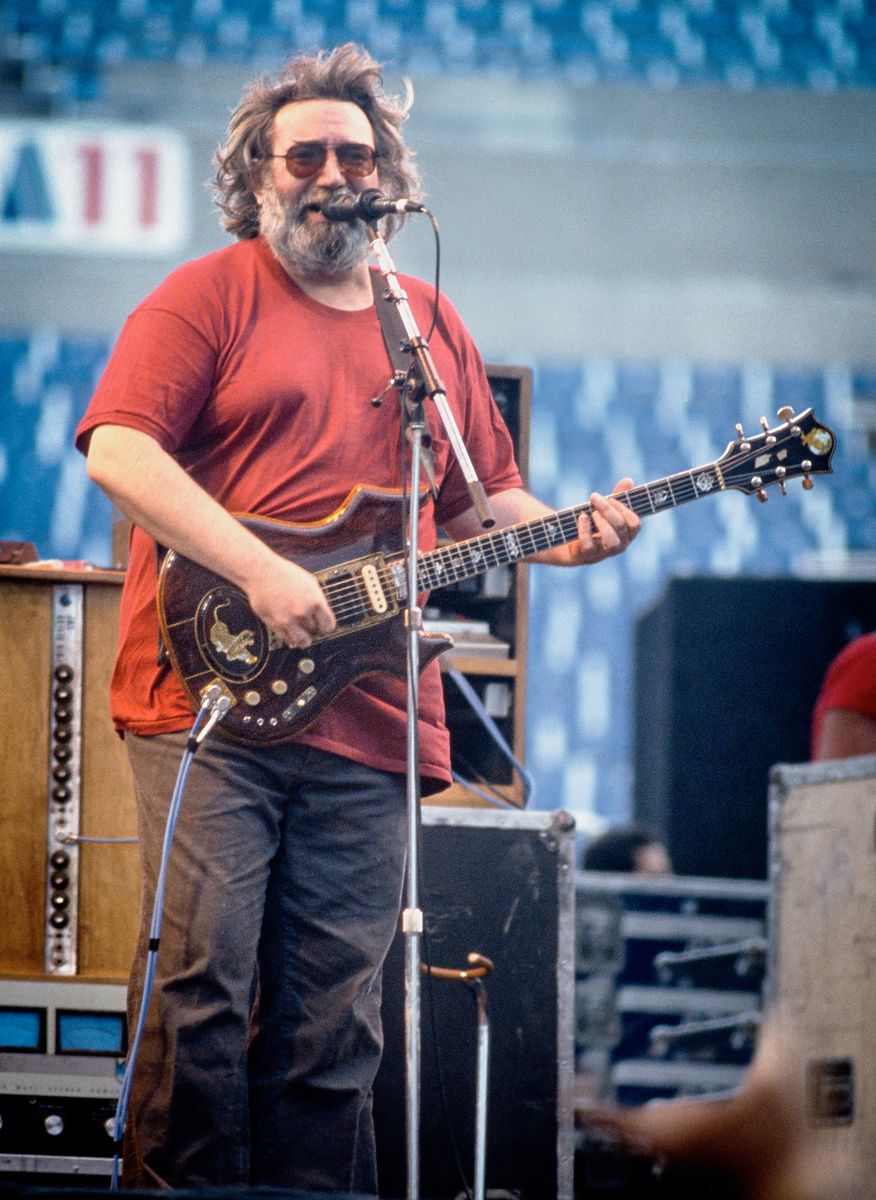 Jerry Garcia of the Grateful Dead performing at Rich Stadium, Buffalo NY, 1986 True Confessions Tour, color portrait, playing his custom-built guitar believed to be Tiger - concert photography by Chuck Spang