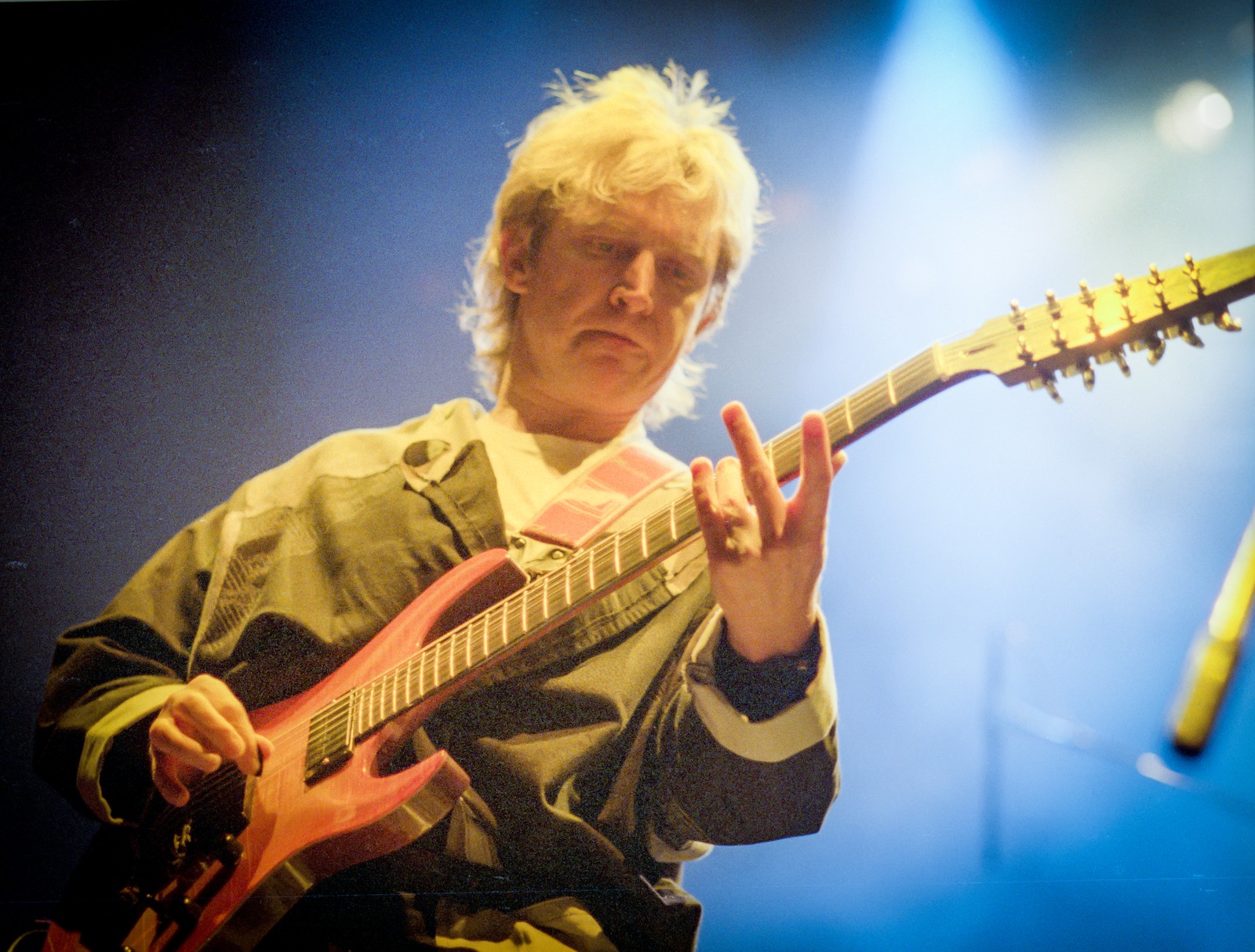 Andy Summers of The Police playing a red guitar under blue stage light at Buffalo Memorial Auditorium, 1984 Synchronicity Tour - concert photography by Chuck Spang