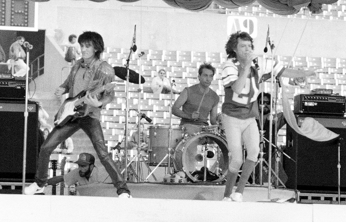 Ronnie Wood and Mick Jagger of the Rolling Stones with a silk streamer blowing in the wind at Rich Stadium, Buffalo NY, 1981 - concert photography by Chuck Spang