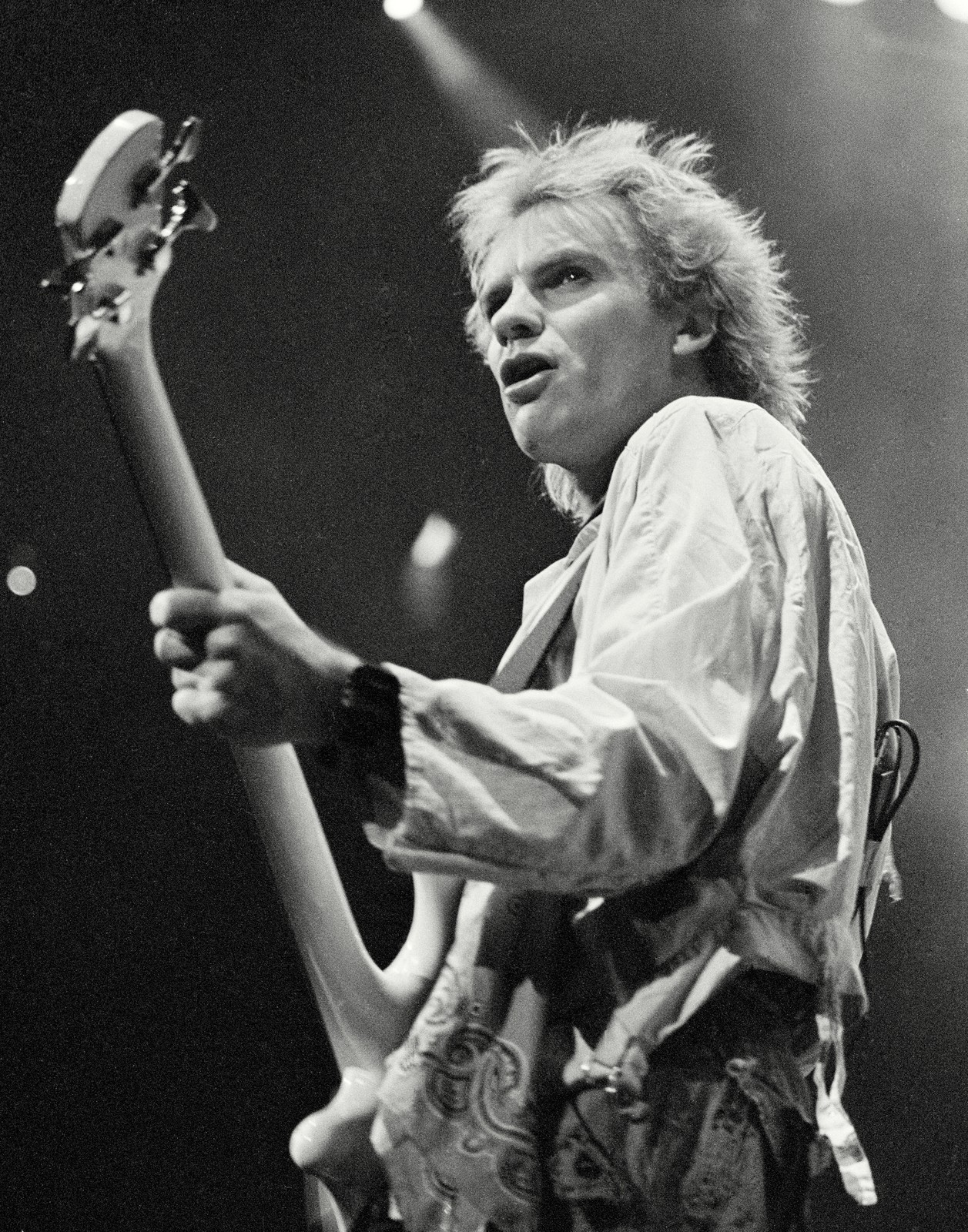 Black and white photo of Sting of The Police with his bass at Buffalo Memorial Auditorium, 1984 Synchronicity Tour - concert photography by Chuck Spang